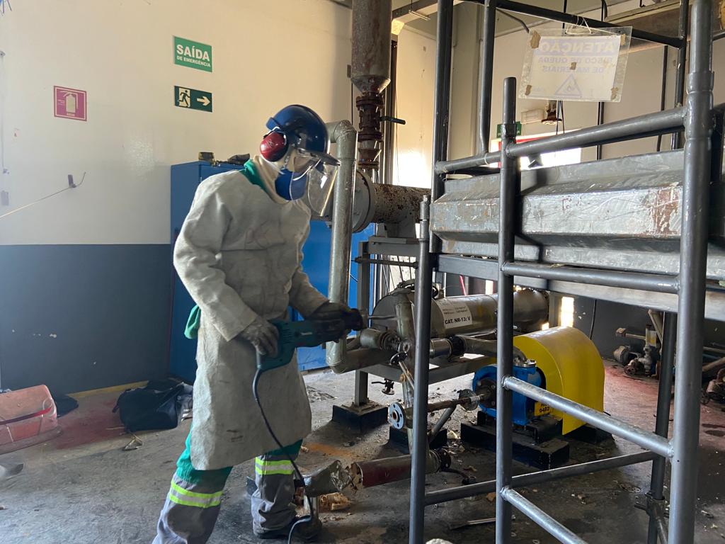Profissional em obra real da R3Ciclo desmontando equipamento industrial em Americana, SP.